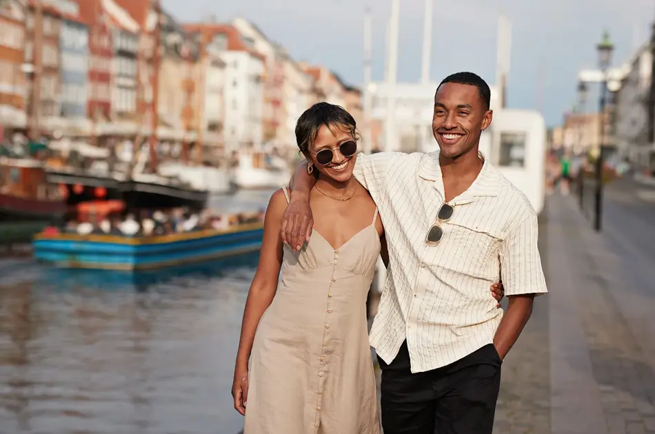 Et lykkelig par går langs gate mens de holder hender 