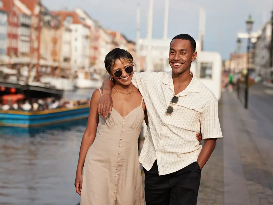 Et lykkelig par går langs gate mens de holder hender 