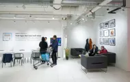 Utsnitt fra Kreftforeningens popup-lokale på Sartor, med sofaområde og utstilte bilder på veggen.