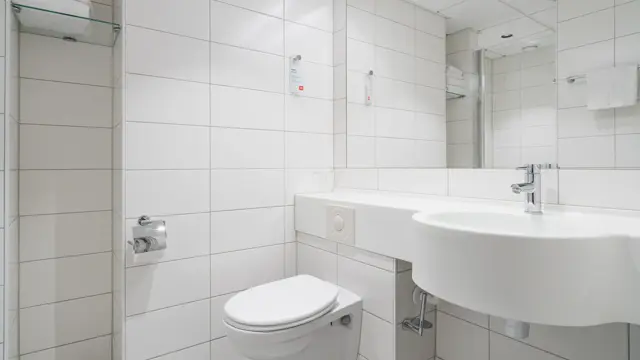 Flislagt bad med dusj, toalett, servant og stort speil