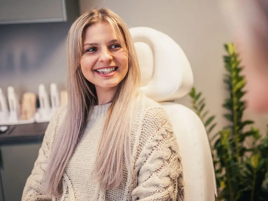 Dame som smiler og sitter i en stol