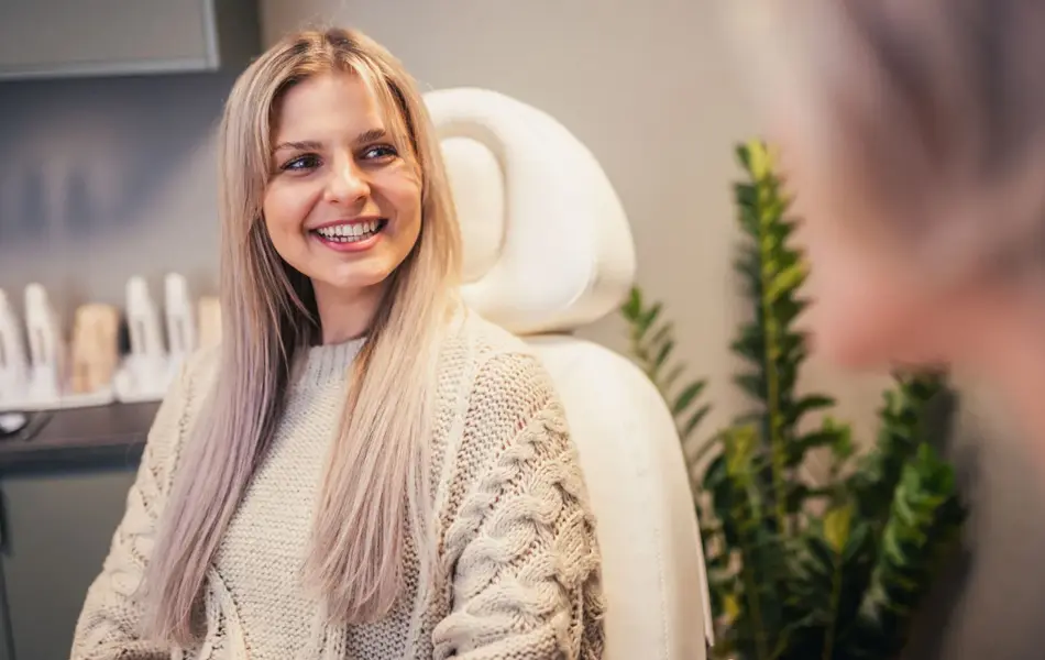 Dame som smiler og sitter i en stol