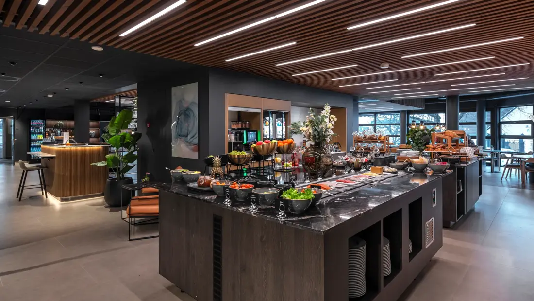 Frokostbuffet med diverse pålegg, grønnsaker og fargerik frukt.