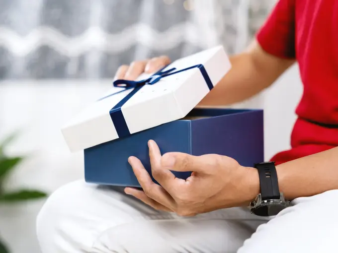A Person Opening A Gift Box