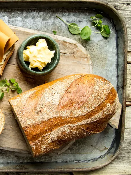 Baker Brun brød og oppskåret brødskive med brunost