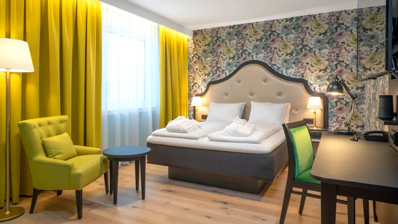 Blomstret tapet og stor dobbeltseng i superiorrom på Thon Hotel Cecil i Oslo sentrum