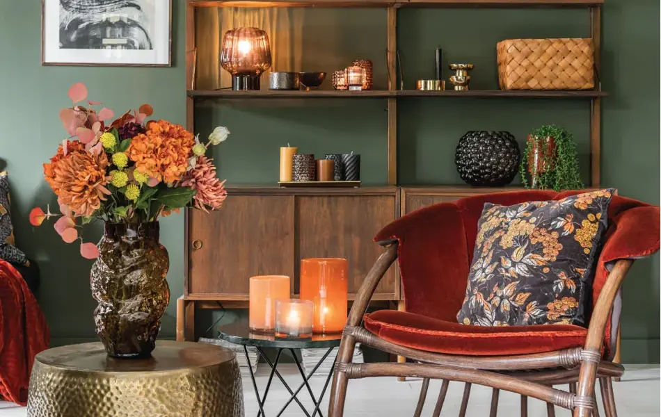 Grønn stue med rød stol og bokhylle dekket med dekor