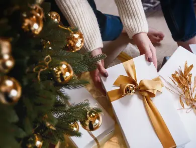 Person henter pakke under juletre