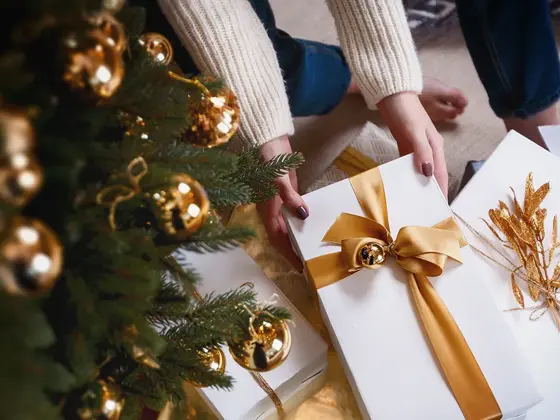 Person henter pakke under juletre