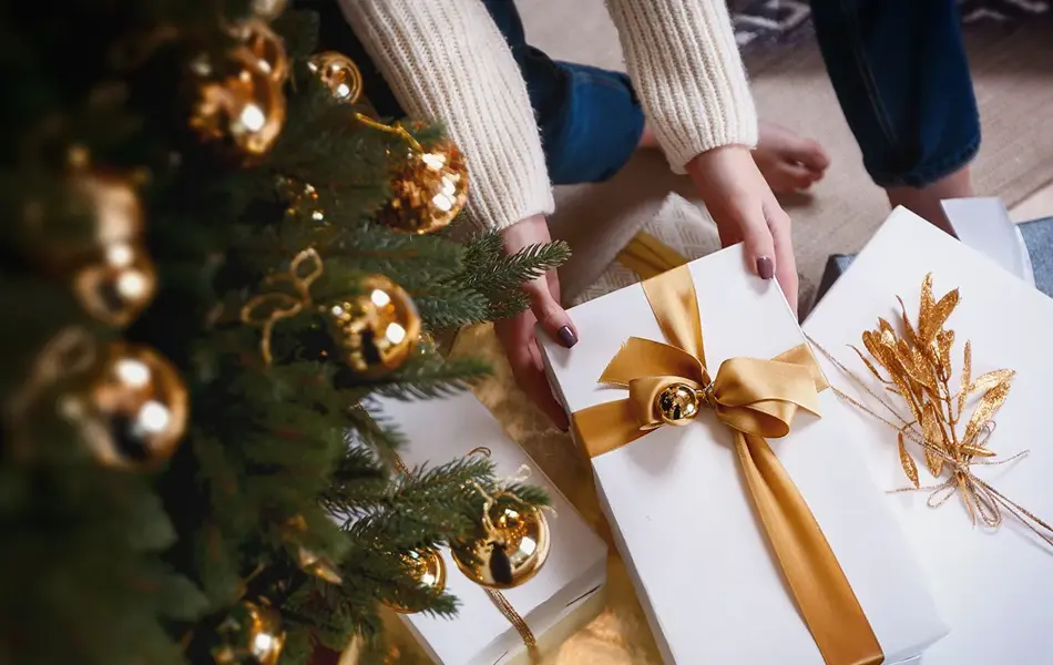 Person henter pakke under juletre