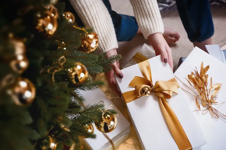 Person henter pakke under juletre