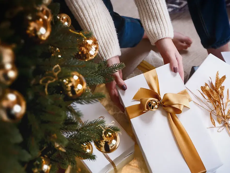 Person henter pakke under juletre