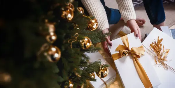 Person henter pakke under juletre