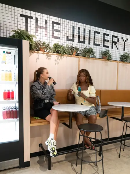 To unge kvinner osm nyter drikke på en kafe