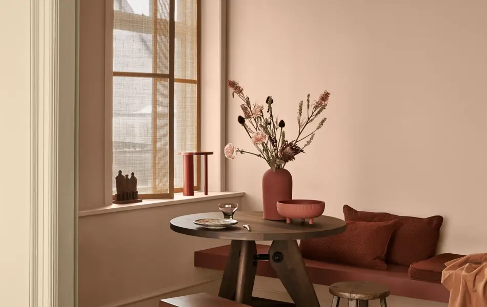 Stuekrok malt i duse rosatoner, med interiørdetaljer i dyp rød