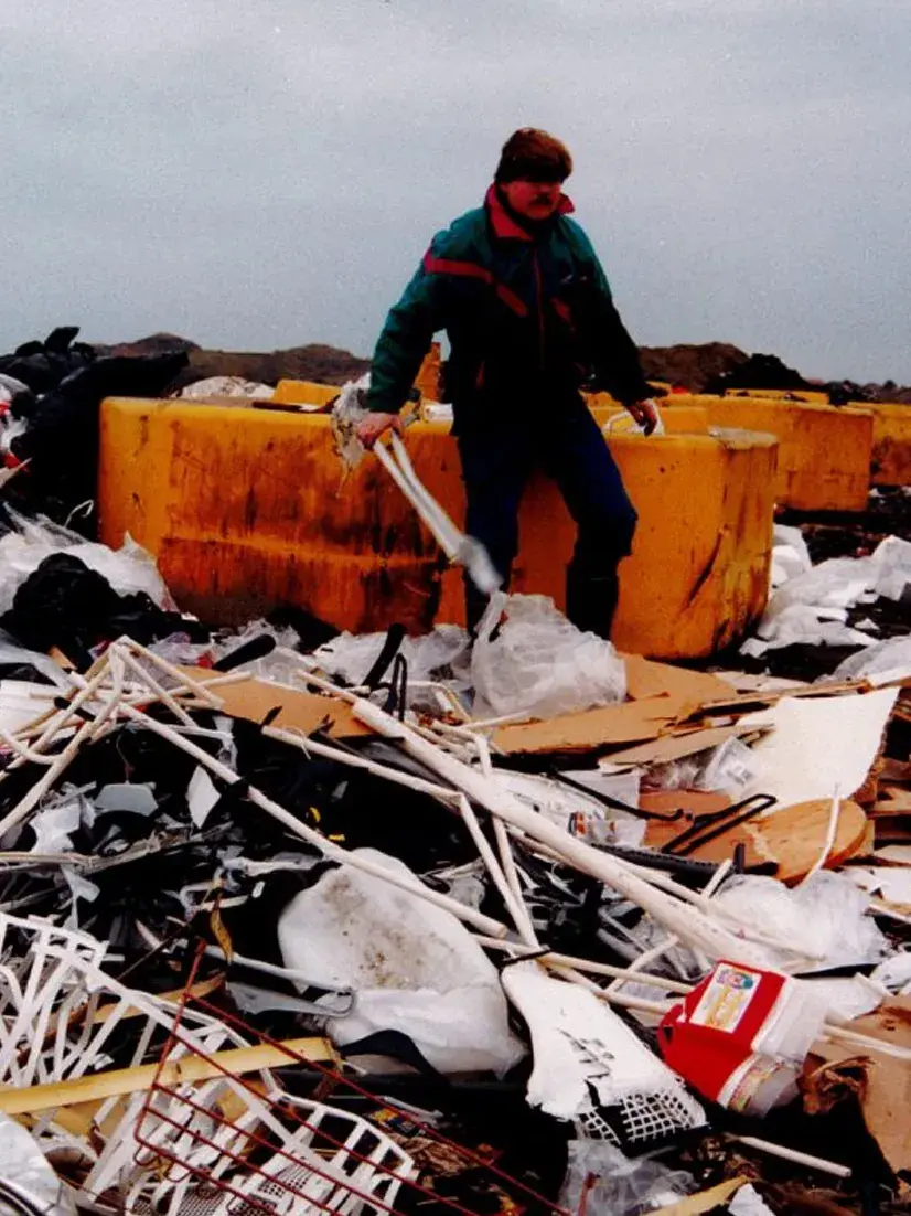 Mann står i en søppeldynge