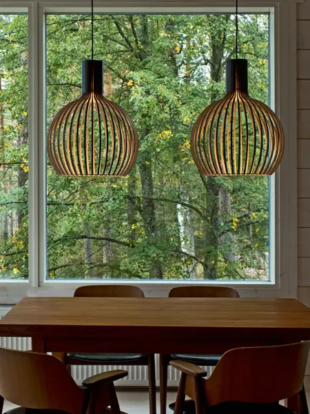 To taklamper i bjørkefiner henger over et spisebord.