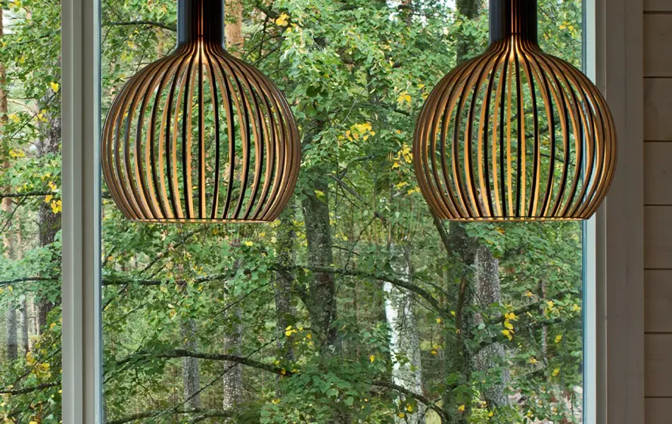 To taklamper i bjørkefiner henger over et spisebord.