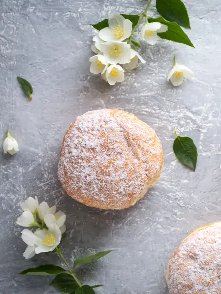 berliner donuts in powdered sugar on a gray background
