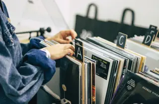 bilde av person som blar i plater fra platebutikk
