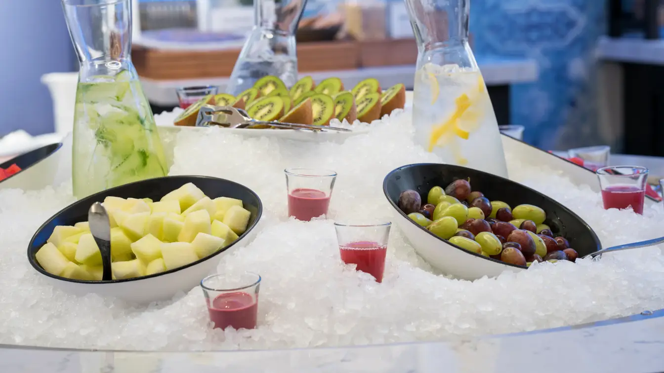 Nærbilde av oppskåret frukt og drikke nedkjølt i is på frokostbuffet ved Thon Hotel Skis frokostsal