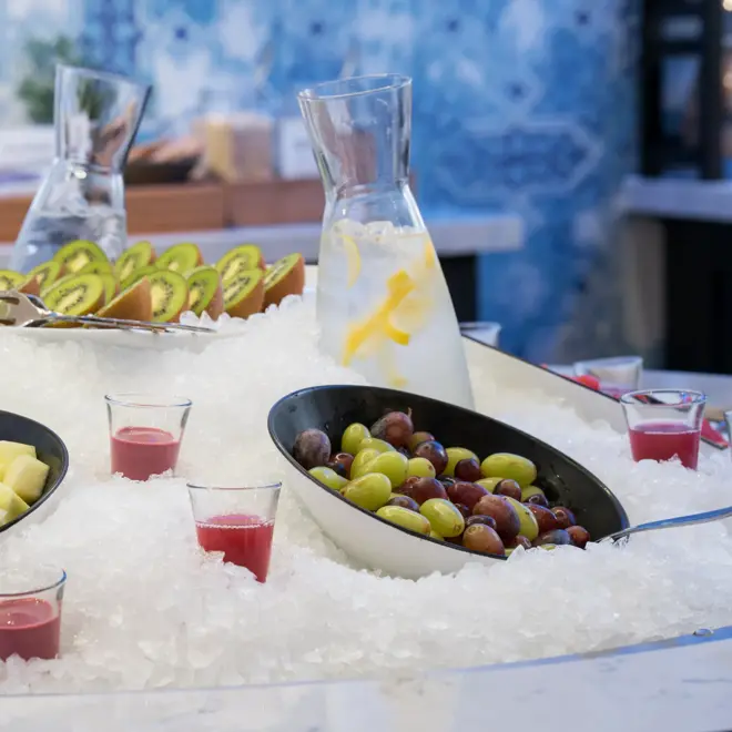 Nærbilde av oppskåret frukt og drikke nedkjølt i is på frokostbuffet ved Thon Hotel Skis frokostsal