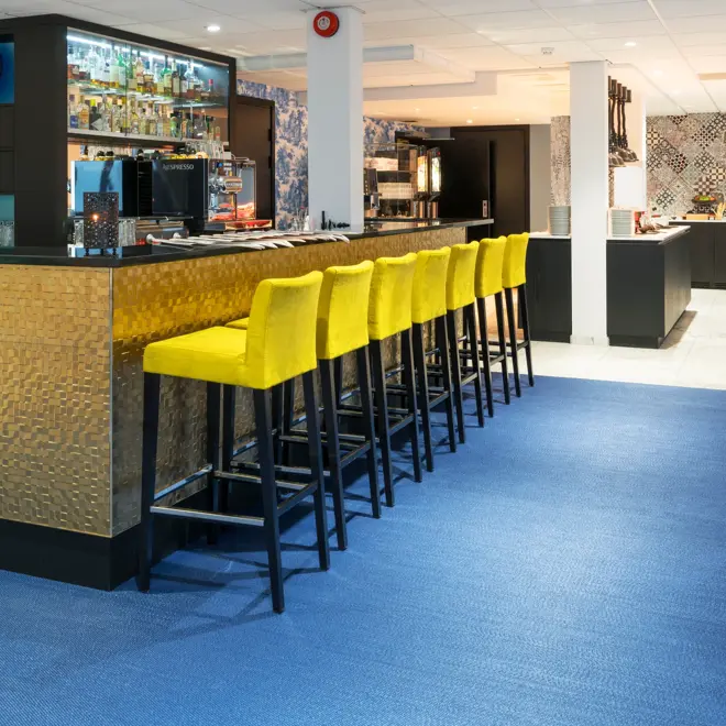 Gule, høye stoler i baren på Thon Hotel Tønsberg Brygge