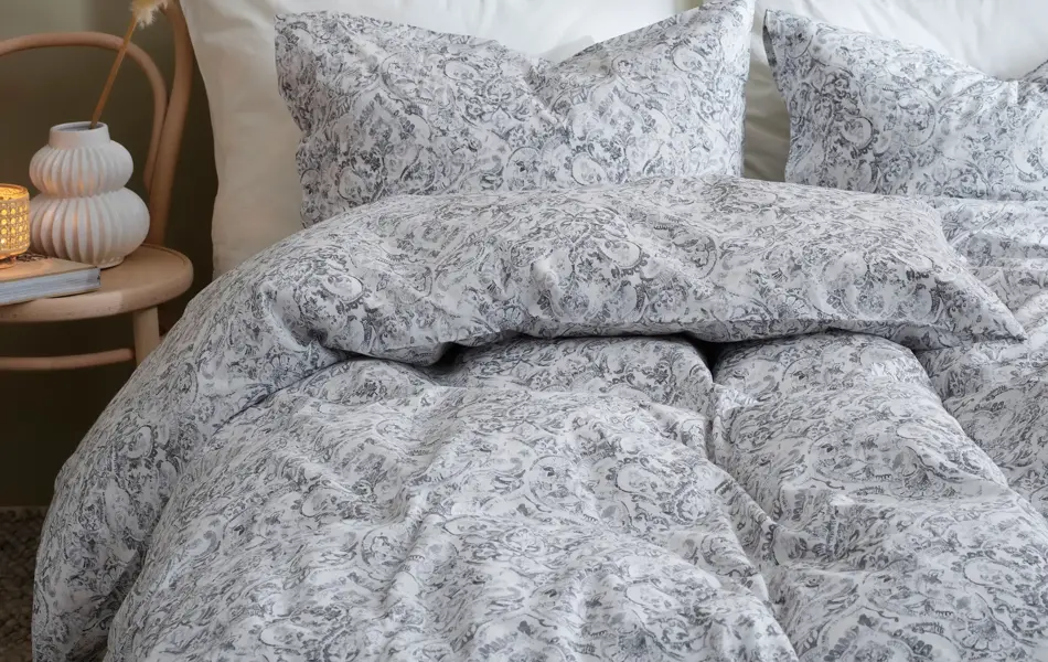 lyst sengetøy med grå blomster