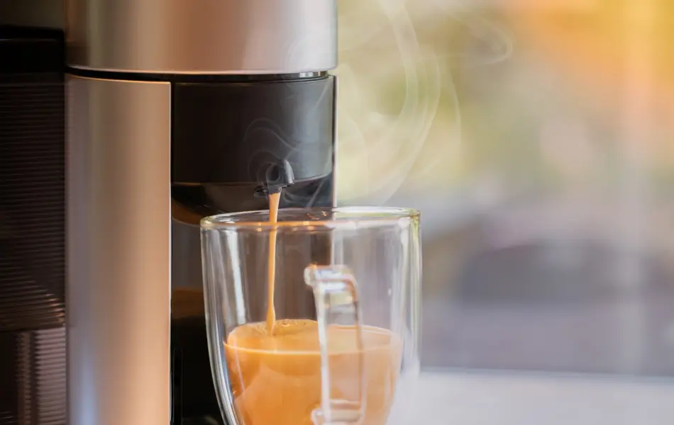 Espressomaskin fyller opp kaffekopp i glass