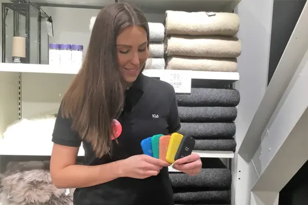 Dame med langt mørkt hår og sort t-skjorte som holder fem forskjellige sprayflasker i hånden