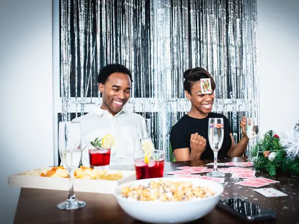 En mann og en dame spiller kort på julefest