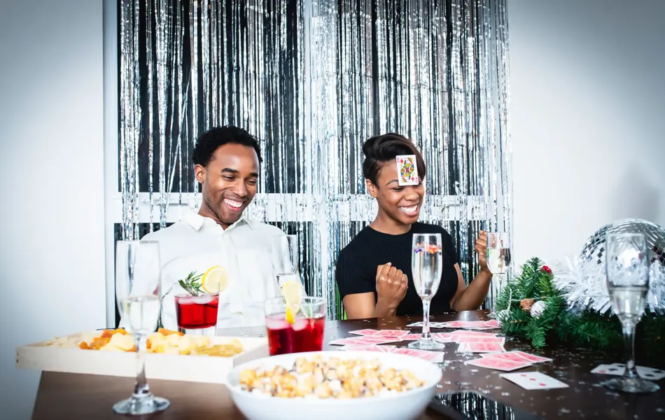 En mann og en dame spiller kort på julefest