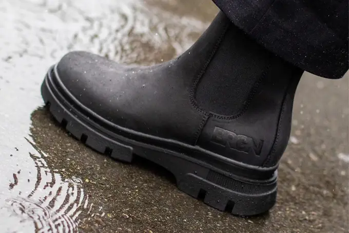 Noen som tråkker en boots i vann