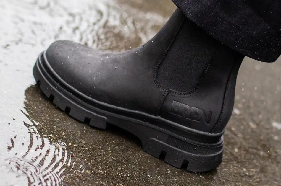 Noen som tråkker en boots i vann