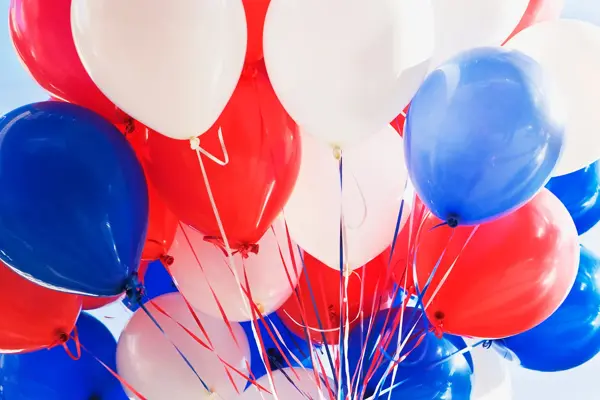 Ballonger i rødt, hvitt og blått på lys bakgrunn. Foto til artikkel om dekorasjoner til 17. mai.
