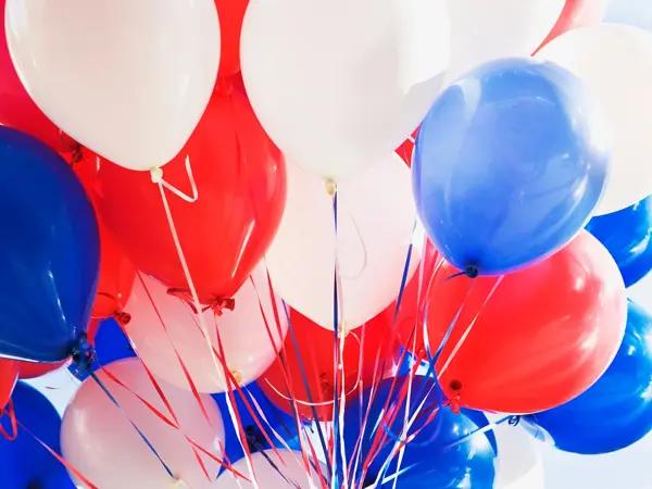 Ballonger i rødt, hvitt og blått på lys bakgrunn. Foto til artikkel om dekorasjoner til 17. mai.
