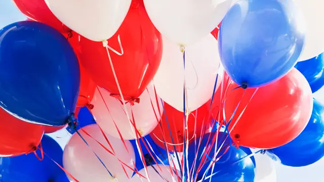 Ballonger i rødt, hvitt og blått på lys bakgrunn. Foto til artikkel om dekorasjoner til 17. mai.