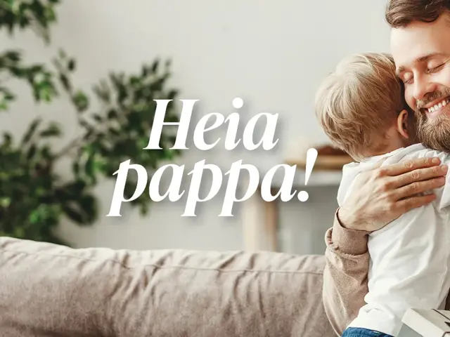 Liten gutt klemmer sin pappa som sitter i sofaen