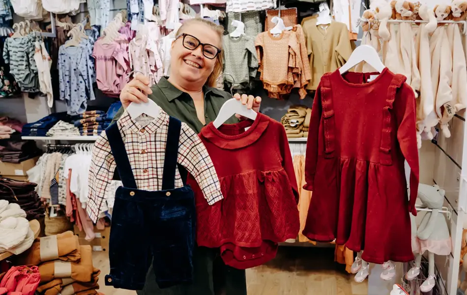 ansatt viser frem julekjoler og juledress