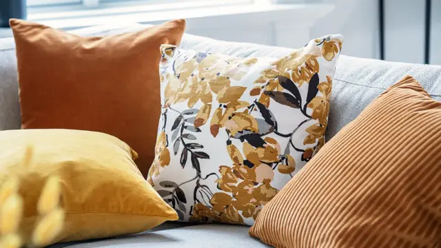 Okergule og orange puter i beige sofa