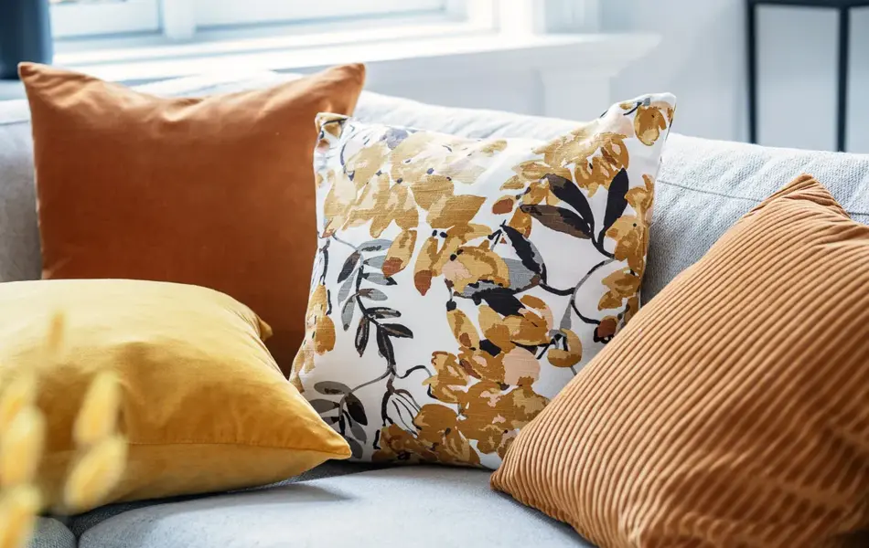 Okergule og orange puter i beige sofa