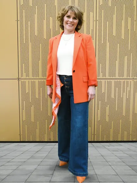 Dame i oransje dressjakke til jeans