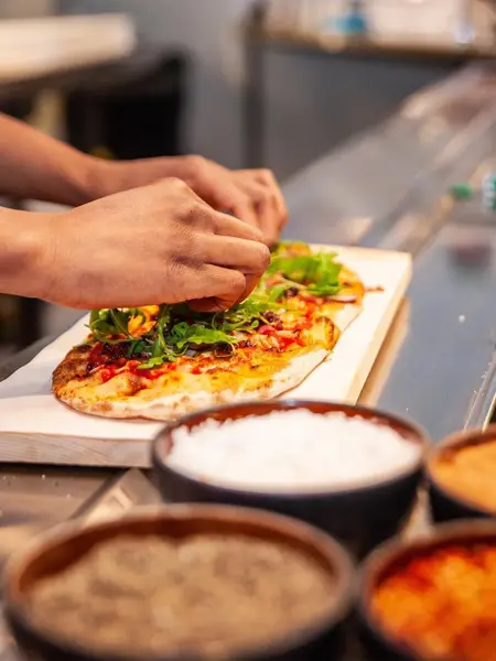 Noen som tilbreder en pizza