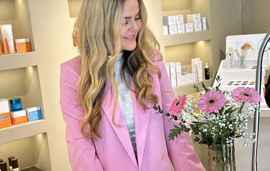 Lyshåret dame med rosa jakke, og hvit topp