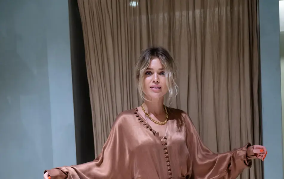 Ung kvinne som poserer i brun silkekjole i prøverom