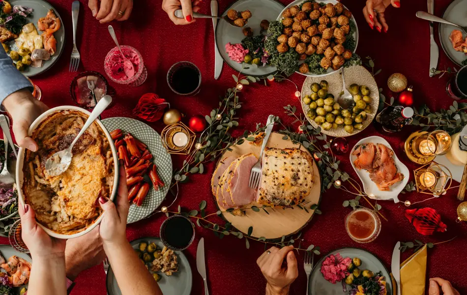 Typical swedish scandinavian christmas smörgåsbord buffet food Photo taken from above overhead table top shot Photot of typical smorgasbord with breaded ham, meatballs, sausauge,noisette, pickled herring and side dishes Julbord med griljerad skinka sill och lax
