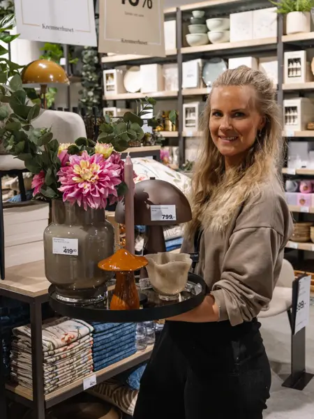 dame holder frem interiør i butikk