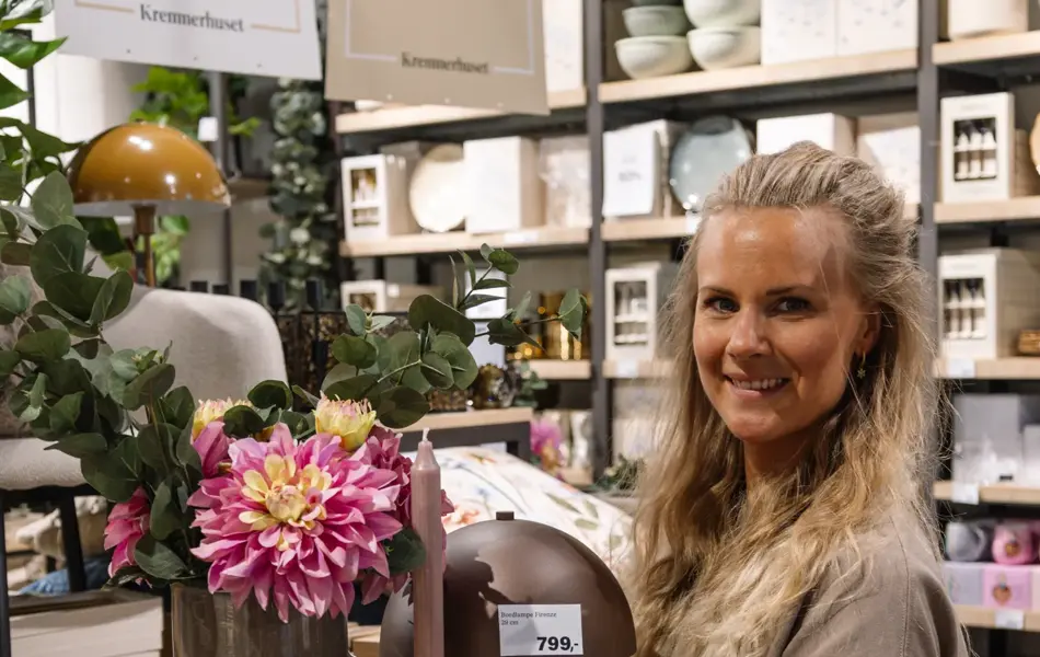 dame holder frem interiør i butikk