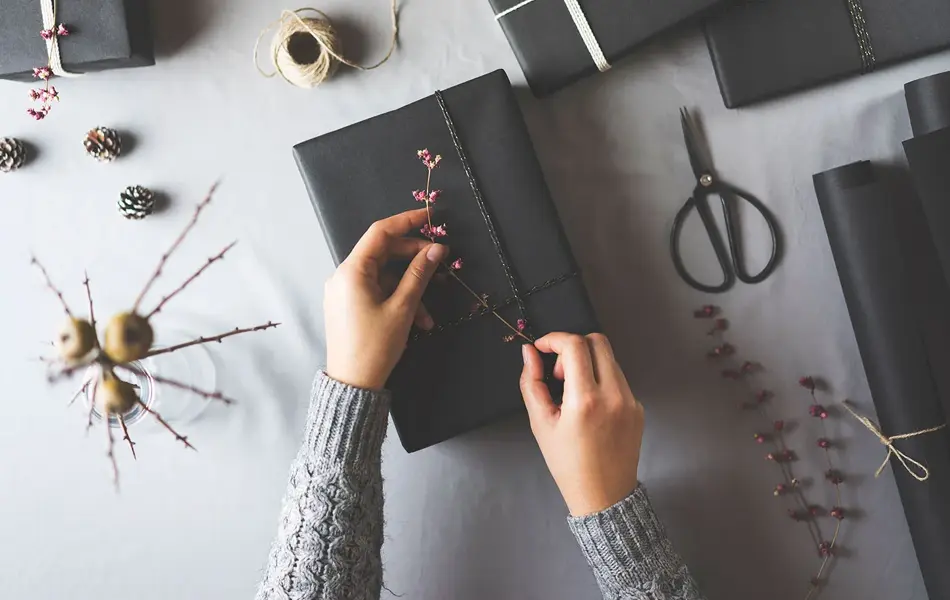 To hender som pakker inn en gave