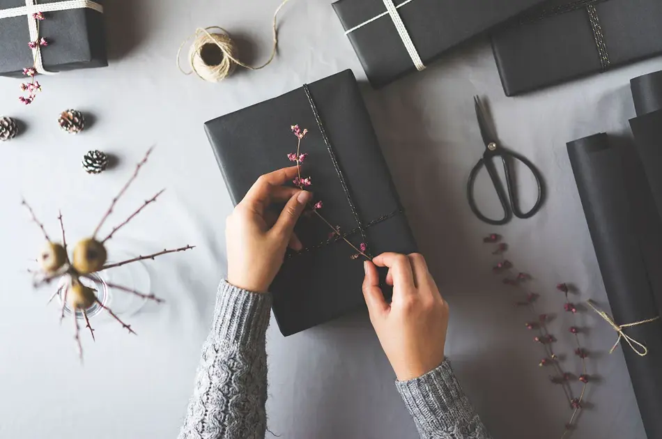 To hender som pakker inn en gave